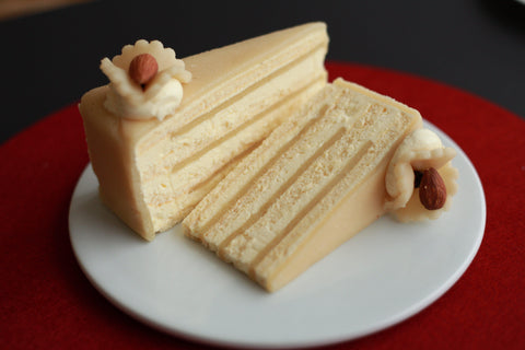 Ein Stück geschichteter Marzipankuchen mit glatter Marzipan-Glasur und feiner Mandeldekoration. Hergestellt mit Lemke Simply Pure Marzipan für einen reichen, authentischen Geschmack.