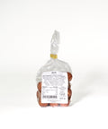 Clear Lemke bag filled with marzipan potatoes with a few pieces placed in front. One cut piece shows the pale marzipan center inside the golden brown cocoa coating.