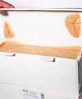 Innenansicht eines geöffneten Kartons mit hellem Haselnuss-Nougat von Lemke