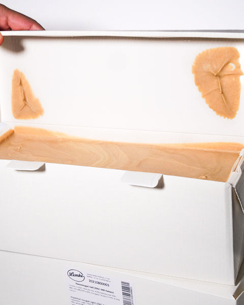 Innenansicht eines geöffneten Kartons mit hellem Haselnuss-Nougat von Lemke