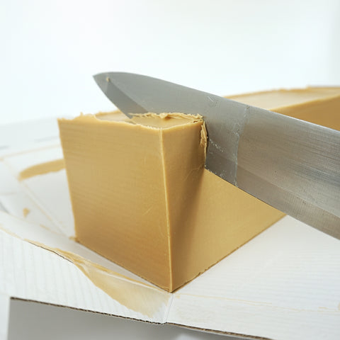 Heller Lemke Haselnuss-Nougat Block wird mit einem Messer geschnitten