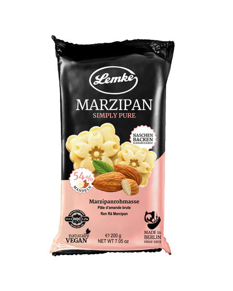 Lemke Marzipan product packaging from Berlin displays a bold black and pink design, featuring delicate flower-shaped marzipan pieces, whole and split almonds, and the Berlin TV Tower silhouette, emphasizing its 54% almond content and vegan ingredients