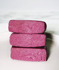 Stacked pieces of Lemke Very Cherry marzipan with pink cherry almond filling on a white plate