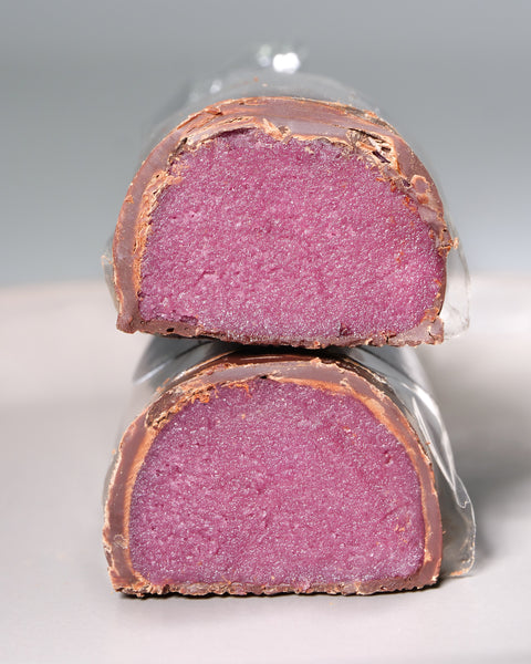 Cut pieces of Lemke Marzipanini Very Cherry with pink cherry marzipan filling and chocolate coating