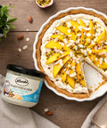 Mango tart topped with Lemke Stadtstreicher Kokos-Mandel Crunchy coconut almond spread and almond flakes