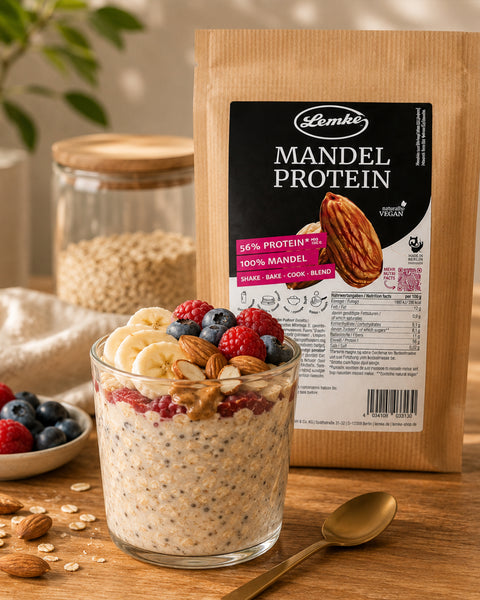 Lemke Mandel Protein 1 kg with a glass of overnight oats topped with banana, berries, almonds, and peanut butter for a protein-rich breakfast.