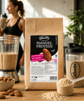 Lemke Mandel Protein 1 kg displayed with a freshly blended protein shake, shaker bottle, whole almonds, and almond protein powder in a fitness-inspired setting.