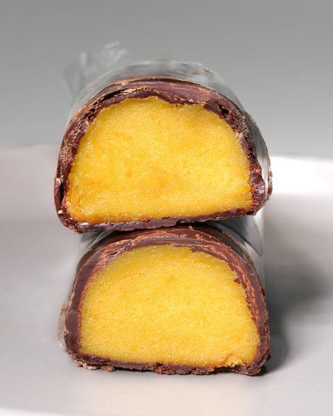 Cut pieces of Lemke Marzipanini Sunny Orange with orange marzipan filling and chocolate coating